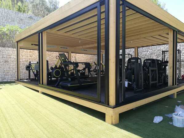 vista exterior gimnasio con revestimiento en madera y amplias cristaleras