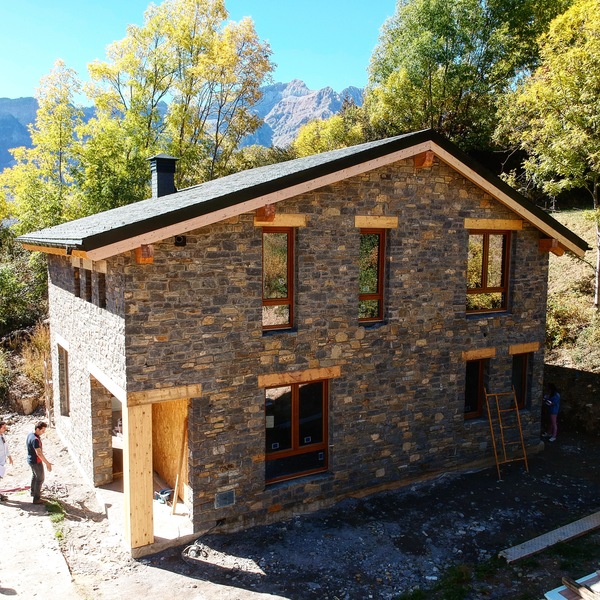vivienda acabada con exterior en piedra tejado de pizarra en jaca en verano